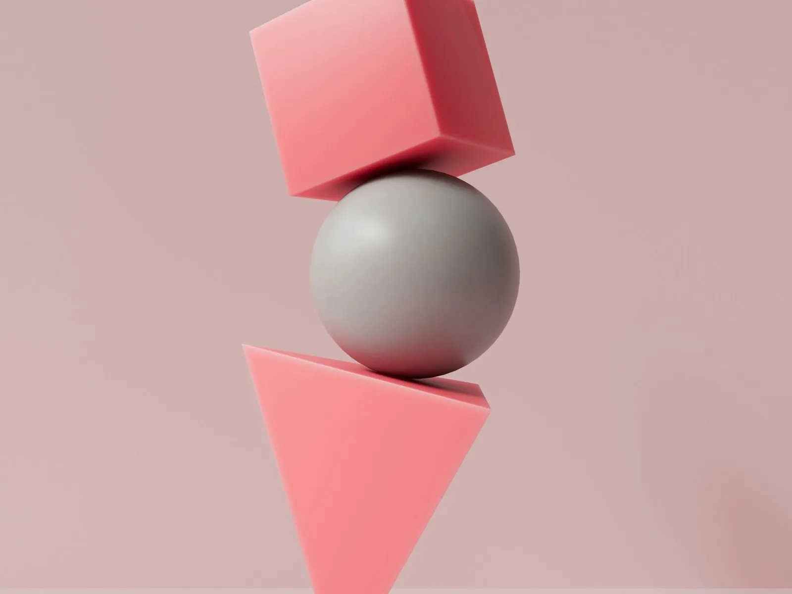 3D render of a grey sphere, coral cube, grey ball and coral cone balanced in a stack on a blush-pink background
